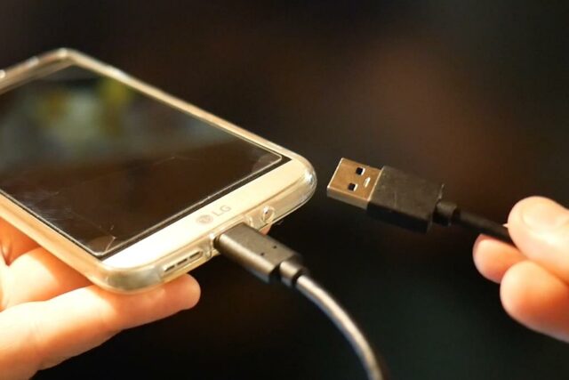 Photo d'un smartphone avec câble USB-C vers USB type A connecté