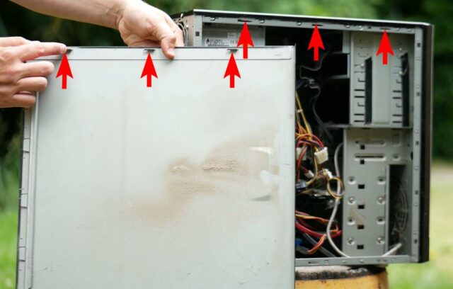 Photo d'un PC fixe ouvert où l'on voit les encoches métal sur le capot qui correspondent aux trous dans le boîtier