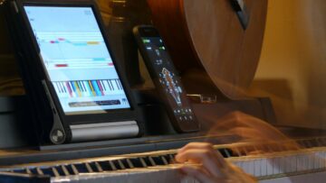 Photo d'une pianiste jouant du piano avec une tablette et un smartphone.
