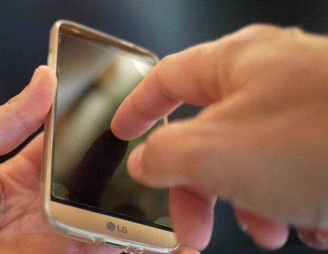 Photo de mon smartphone LG G5 avec mon doigt posé dessus, l'écran est noir