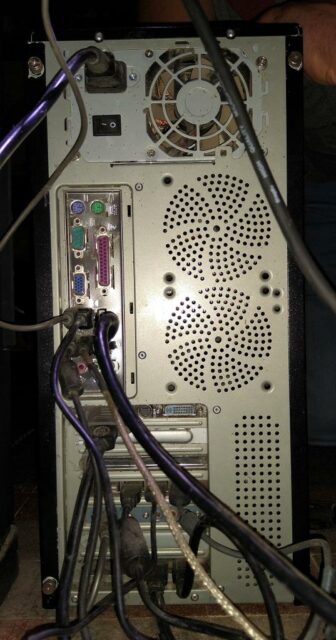 Photo de l'arrière d'un PC fixe avec plein de câbles branchés
